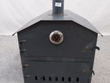 un petit poêle en métal surmonté d'une horloge