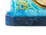 a clock that is sitting on top of a blue base