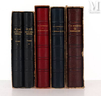 three old books are lined up on a white surface