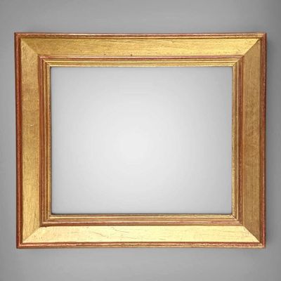 an image of a gold framed mirror against a gray wall