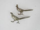 pair of silver plated pheasants on a white surface