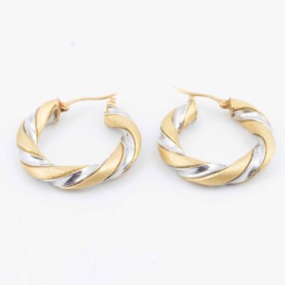 two tone twisted hoop earrings on a white background