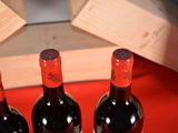 three bottles of wine sitting on a red table