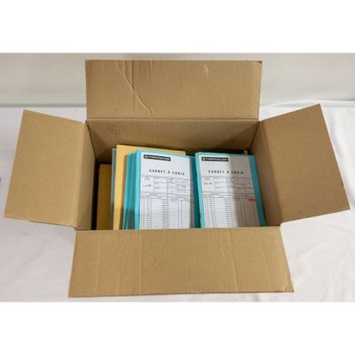 a box of books sitting on top of a bed next to a white sheet