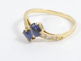 a close up of a gold ring with a blue sapphire and white diamonds