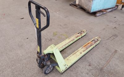 a fork lifter sitting on the ground next to a pallet