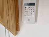 a remote control on the wall next to a wooden panel