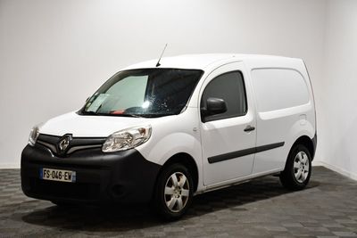 La camionnette blanche est garée dans une pièce au sol noir.