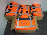 quatre cartons de gilets orange posés par terre
