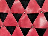 red, black, and white leather bag with metal studs on it