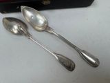 two spoons sitting next to each other on a table