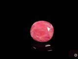 a close up of a pink stone on a black surface