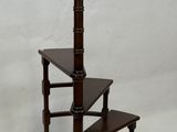 a picture of a three - tiered wooden shelf with a lamp on top