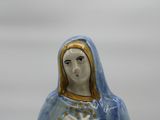 a figurine of the virgin mary holding a cross
