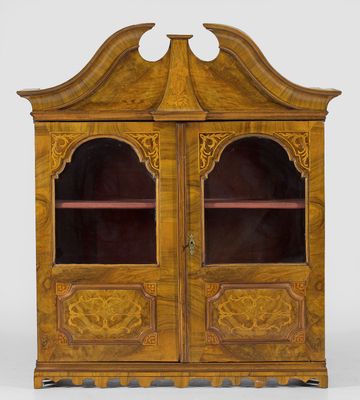 une armoire ancienne en bois à deux portes, dont l'une est vitrée