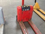 a red forklift sitting in the middle of a warehouse