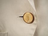 a gold button on a white jacket that has a y sign on it