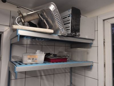 a metal shelf that has some pots and pans on it