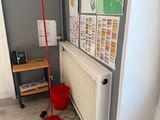a red floor lamp sitting next to a radiator in a room