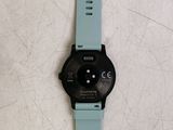 the watch is sitting on a white surface next to a blue strap