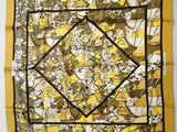 a yellow and black square scarf with a picture of people on it