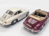 two toy cars sitting next to each other on a white surface