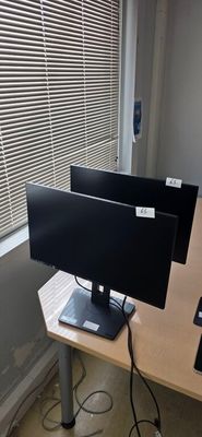 a computer desk with two monitors and a keyboard on it