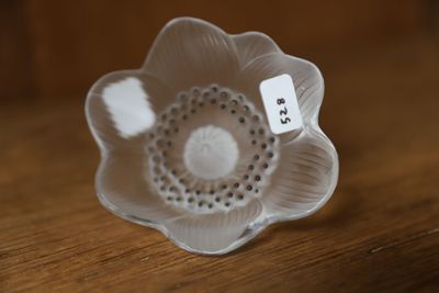 un petit objet en forme de fleur blanche posé sur une table en bois