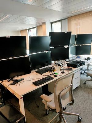 trois écrans d'ordinateur posés sur le bureau de ce bureau