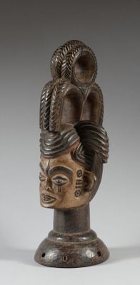 un gros plan sur une statue représentant une tête surmontée d'un serpent