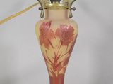 a red and yellow vase with a gold handle on a white background