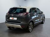 the back end of a grey car parked in a showroom