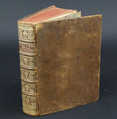 an old book sitting on top of a table next to a black background