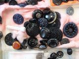 a lot of black buttons and buttons in a box