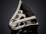 a black and white diamond ring on a black surface