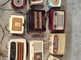 many old radio ' s laid out on the floor