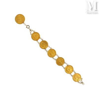 un gros plan d'un bracelet composé de pièces d'or sur fond blanc