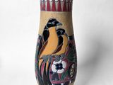 un vase orné d'un oiseau peint, posé sur une table