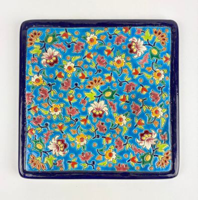 un gros plan d'une assiette bleue décorée de fleurs et de feuilles