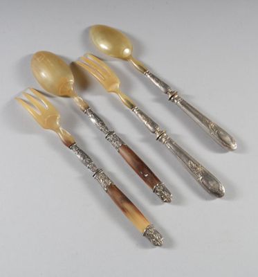 quatre fourchettes et cuillères sont alignées sur une surface blanche