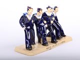 three figurines of men in blue uniforms on a wooden base