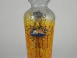 a yellow vase with a design on it on a white background
