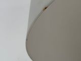 a close up of a white lamp with a brown spot on it