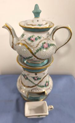 a tea pot sitting on top of a stack of tea cups