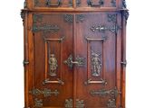 une photo d'un meuble ancien en bois dont les portes sont ornées de sculptures