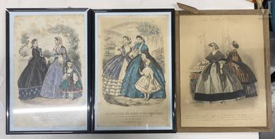 three framed pictures of women in dresses on display in a room