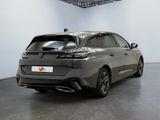 the rear end of a grey car in a white room