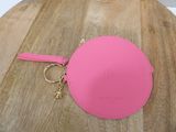 pink coin purse with keychain on wooden table