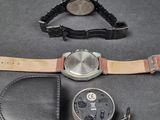 a watch that is laying next to a watch case
