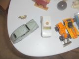 une table blanche sur laquelle sont disposées des petites voitures et d'autres jouets